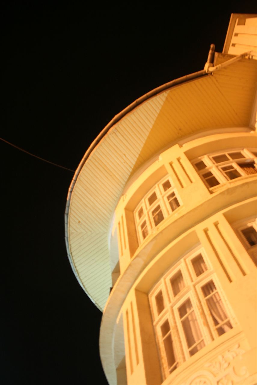 Curved building facade lit warmly at night
