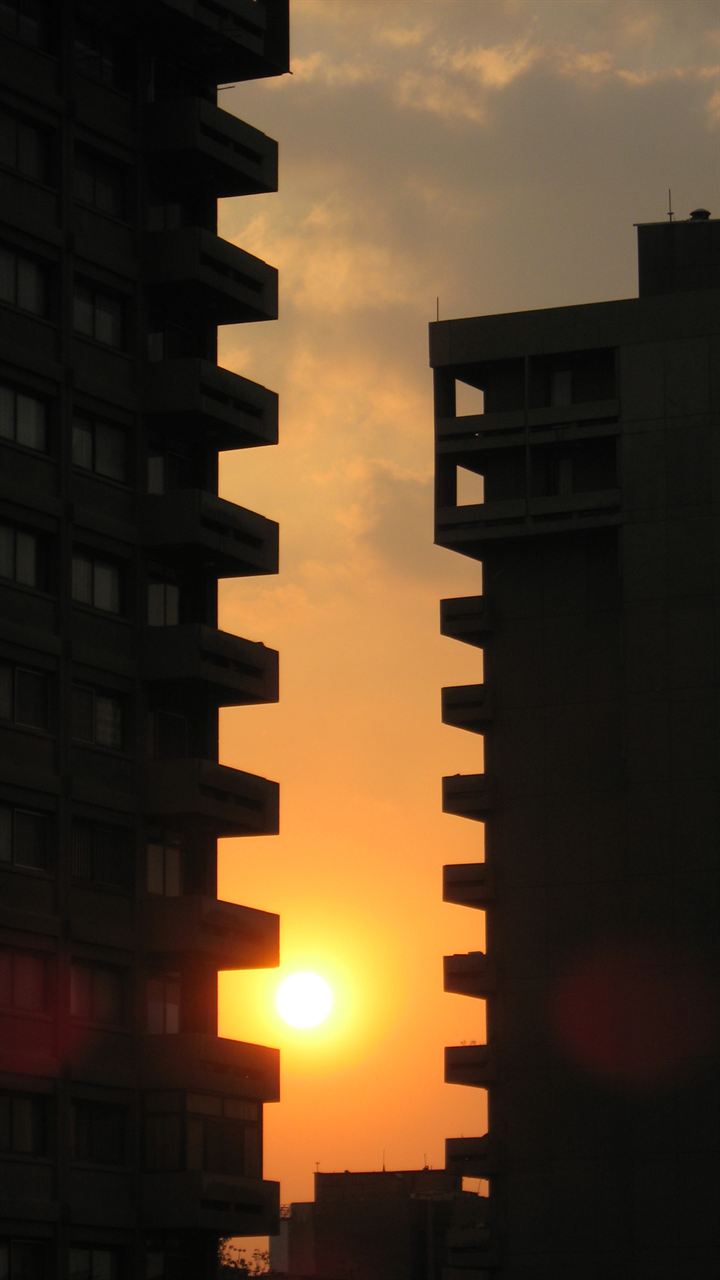 Tall building silhouetted at sunset